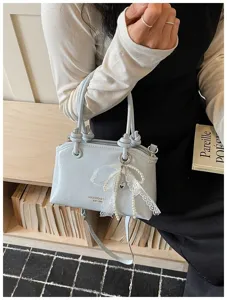 Hellblaue Handtasche Umhängetasche mit Perlen Schleife Anhänger für Damen Mode.