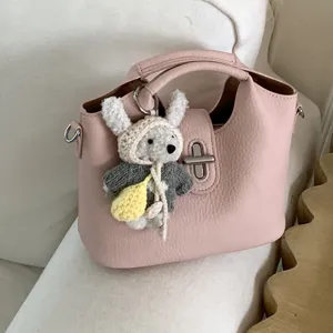 Rosa Umhängetasche Damen Lederoptik Beuteltasche mit süßem Stricktier Anhänger für Alltag.