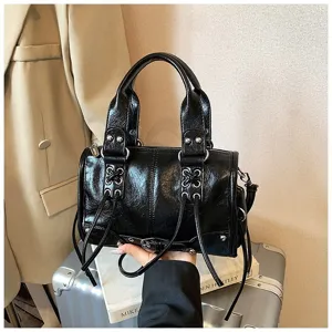 Detailansicht der schwarzen Leder-Motorradtasche mit Nieten, Doppelgriffen und Riemen.