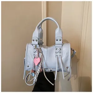 Hellblaue Motorrad Handtasche Detail mit Nieten, stilvollen Riemen und einem süßen Herzanhänger.