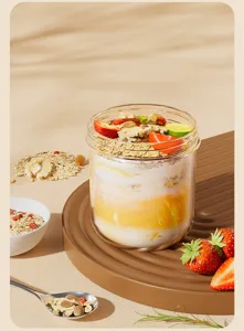 Detailansicht des transparenten Glas-Frühstücksbechers mit geschichtetem Joghurt und Haferflocken.