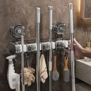 Wall-mounted mop and broom holder punch-free suction cup storage rack for bathroom cleaning tools.