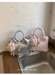 Vue détaillée du sac à main seau élégant pour femme en argent et rose avec charm.