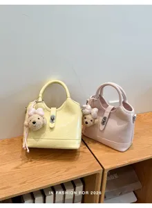 Élégant sac seau en cuir synthétique avec adorable pendentif ours pour femmes au quotidien.