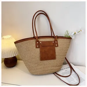 Grand sac cabas en paille tisseedetails en cuir marron, ideal pour les deplacements detetes.