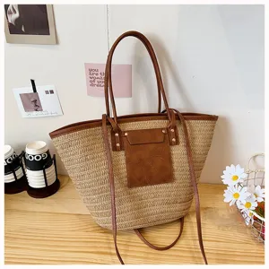 Élégant cabas tissé en paille pour femmes, grand sac porté épaule avec bordure marron.
