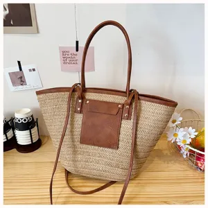 Vue détaillée du sac cabas en paille tissée élégant avec poignées et poche avant en cuir.