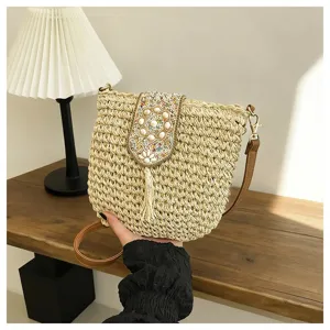 Vista detallada del elegante bolso cruzado de paja con solapa de cuentas y borla.