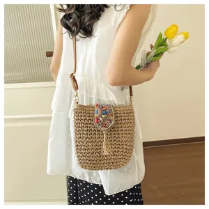 Bolso bandolera de paja tejida con solapa de cuentas colorida y detalle de borla.