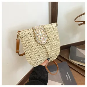Vista detallada del bolso cruzado de paja tejida con solapa de abalorios y borla, bolso de playa.