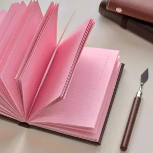 Close-up of A6 leather notebook with pink lined inner pages and elegant design detail.