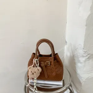 Stylish brown woven bucket bag with cute bear pendant for women, chic daily crossbody purse.