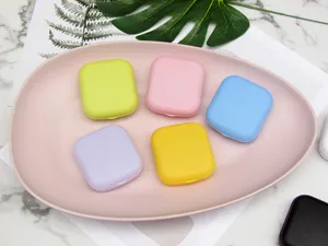 Close-up detail showing colorful small square contact lens companion cases arranged neatly.