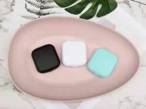 Detail shot of compact square contact lens cases in multiple colors, neat portable design.