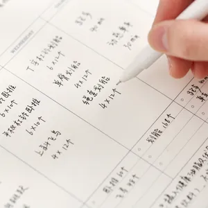 Detailed view of the weekly planner notebook with handwritten schedule and daily task grids.