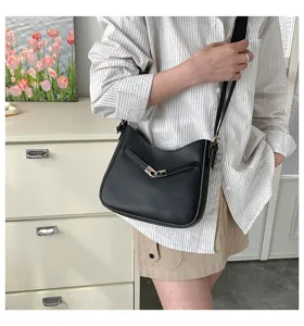 Detailed view of the stylish black leather shoulder bag worn by model, chic design.