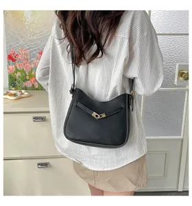 Detailed view of a stylish black women shoulder crossbody bag with metallic clasp.