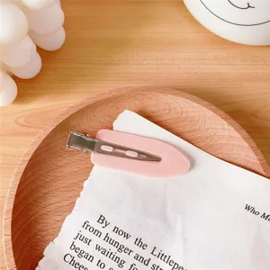 Close-up detail of a cute pink seamless hair clip, perfect for makeup and daily hairstyling use.