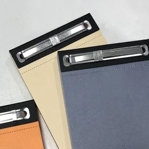 Creatief memo-notitieboekje met metalen clip, minimalistische kantoorartikelen en planning.