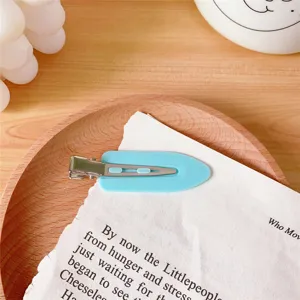 Light blue seamless hair clip detail view, minimalist duckbill clip for elegant styling.