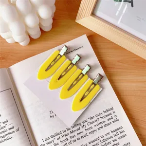 Close-up detail of yellow no-crease makeup hair clips, set of four on card.