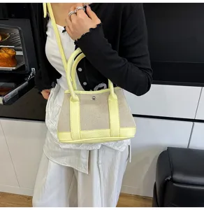 Stylish contrast canvas handbag for women, chic crossbody bag with top handle and strap.