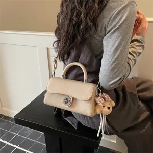 Moderna borsa a tracolla quadrata beige in pelle elegante con chiusura a torsione.