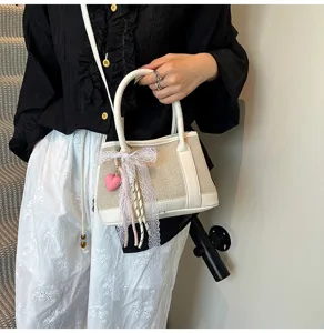 Chic contrast color crossbody bag for women, stylish handbag with lace ribbon and heart charm.