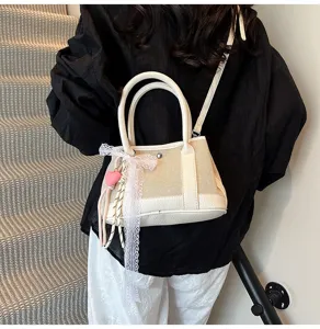 Chic contrast color canvas handbag with lace bow and cute heart pendant for women daily wear.
