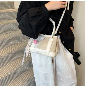 Chic canvas crossbody bag for women with cute heart charm, stylish small handbag daily use.