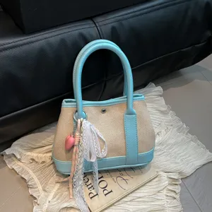 Stylish canvas contrast color handbag with cute lace bow and heart charm for daily casual wear.