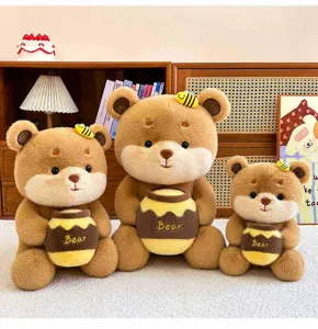 Detail view of cute honey bear plush toys holding honey pots, soft and cuddly gift choice.