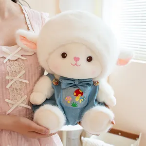 Adorable peluche mouton avec salopette en denim bleu, poupée en peluche douce pour cadeau de fille.