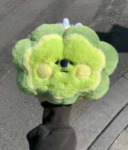 Vista dettagliata di questa simpatica bambola di peluche verde con un viso dolce e carino.