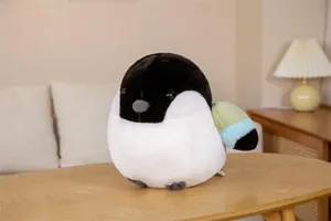 Close-up view of the cute fat bird plush toy on a wooden table, cozy home background setting.