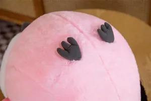 Close-up of the cute pink plush bird toy, showing soft fluffy fabric and cute little feet details.