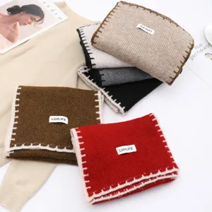Detailed view of women's cozy knitted winter scarves with wool blend and stylish contrast edges.