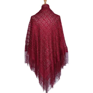 Red lace fringe shawl detail showing intricate hollow floral pattern and elegant dangling threads.