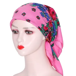 Close-up detail of the pink floral headscarf showing vibrant traditional folk print patterns.