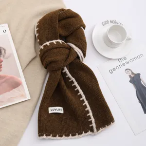 Detailed shot of women's cozy knit winter scarf with contrast stitch trim and label accent.