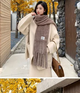 Detailed view of the plush winter scarf featuring soft fleece texture and elegant tassel design.