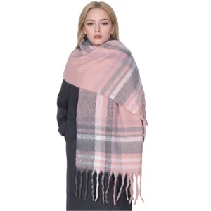 Close-up detail of the cozy pink and grey plaid winter scarf featuring a stylish tassel hem.