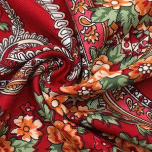 Detailed shot of a red ethnic floral print scarf, showing rich texture and vintage design.