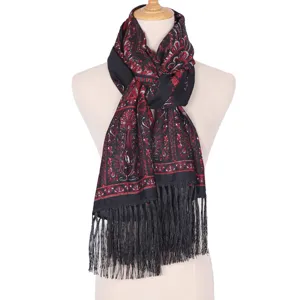 Detailed view of the black ethnic print scarf with red paisley patterns and chic fringe design.