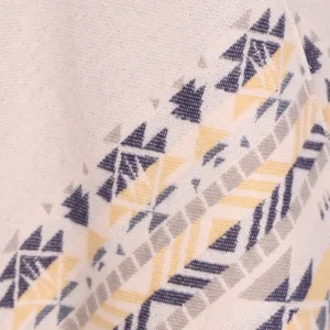 Detailed view of women's warm winter knit shawl cape with ethnic geometric pattern fabric.