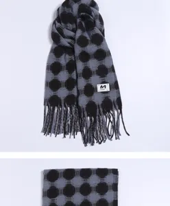 Close-up detail of soft imitation cashmere winter scarf with polka dot pattern and stylish fringe.