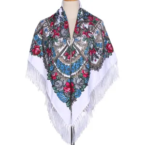 Detailed view of traditional Russian style floral square scarf with white fringe and warm fabric.