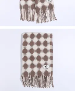 Detailed view of women winter brown polka dot warm scarf with fringe and brand label.