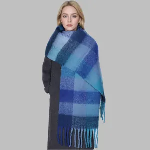 Detail view of thick mohair plaid scarf, cozy blue winter shawl and warm fringed winter wrap.