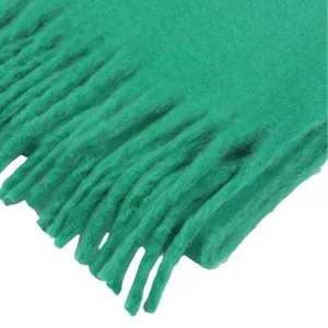 Nahaufnahme des lebendigen grünen Winter Mohair Schals mit weichen strukturierten Fransen.